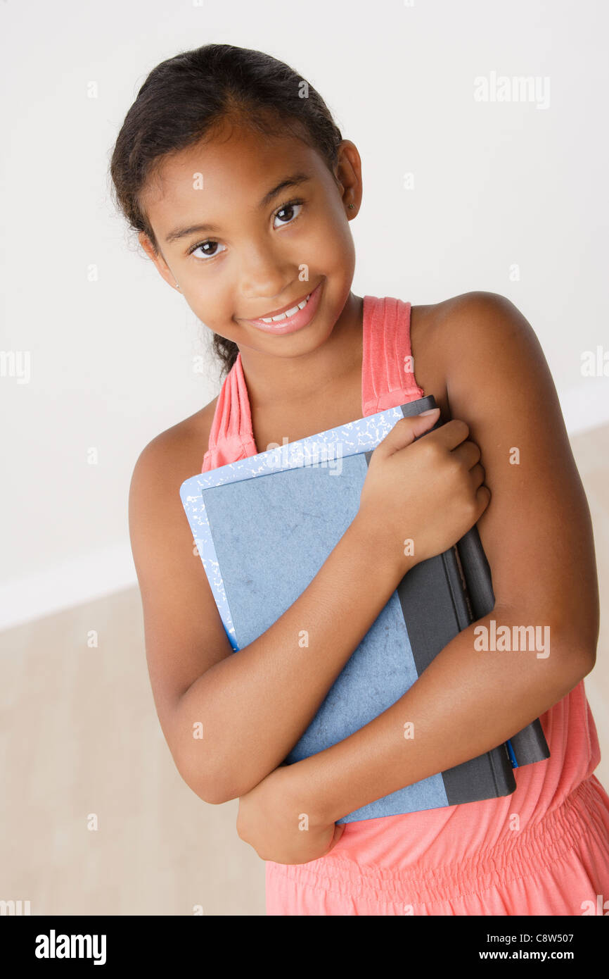 Studio portrait of girl holding books Stock Photo - Alamy