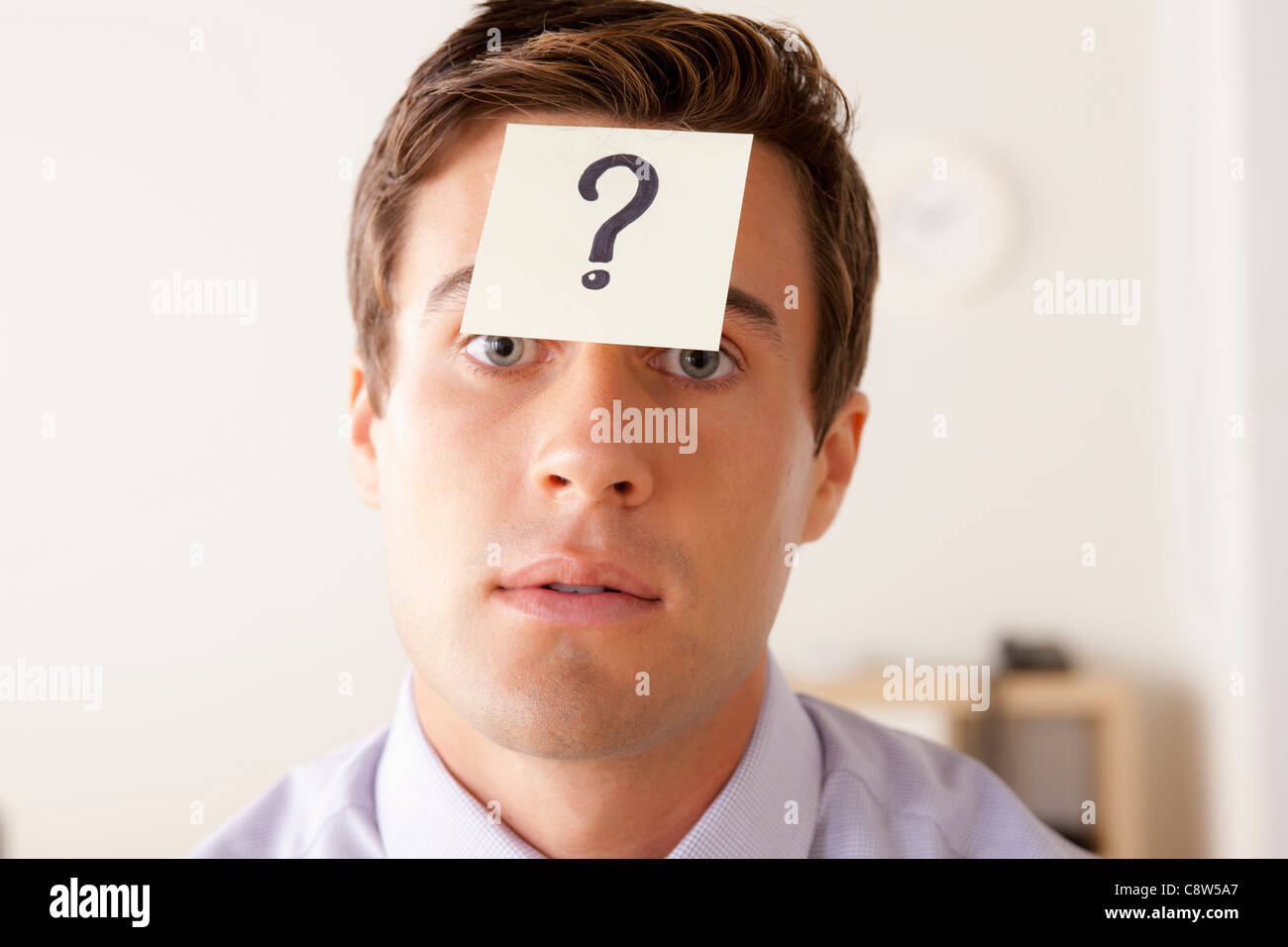 Portrait of businessman with adhesive note attached on forehead Stock Photo