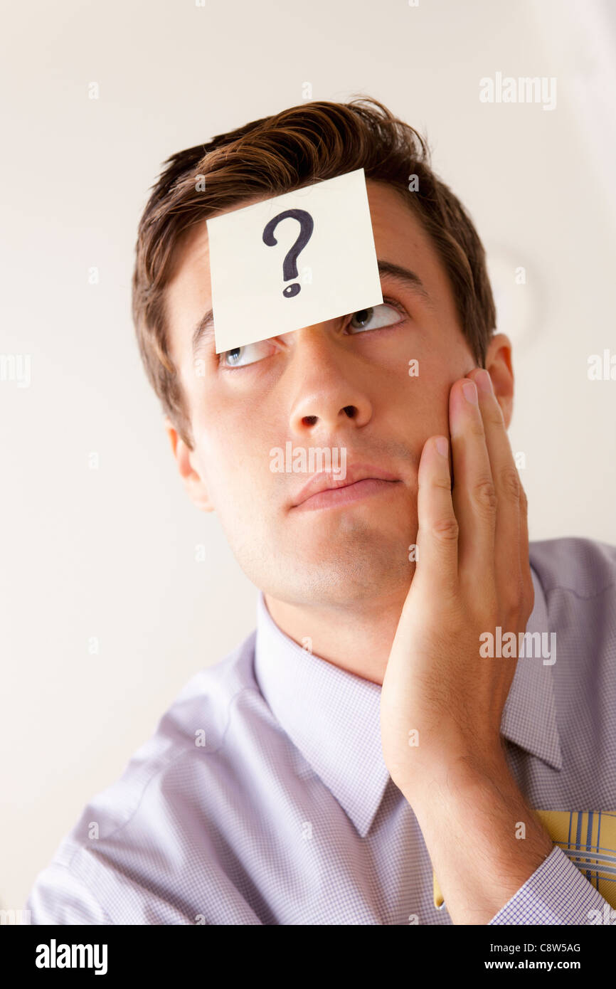 Portrait of businessman with adhesive note attached on forehead Stock Photo