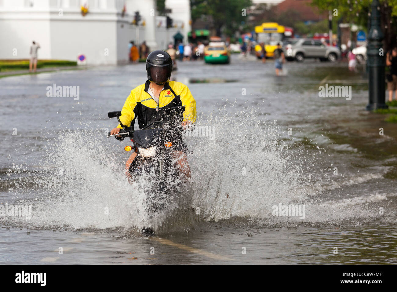 Motorbike riding through flood water in Bangkok city centre, Thailand