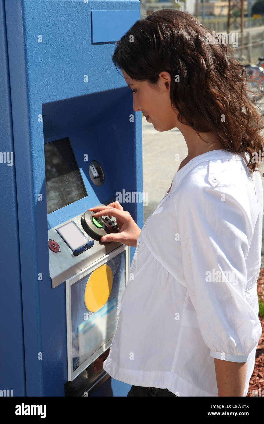 young woman using ticket machine Stock Photo - Alamy
