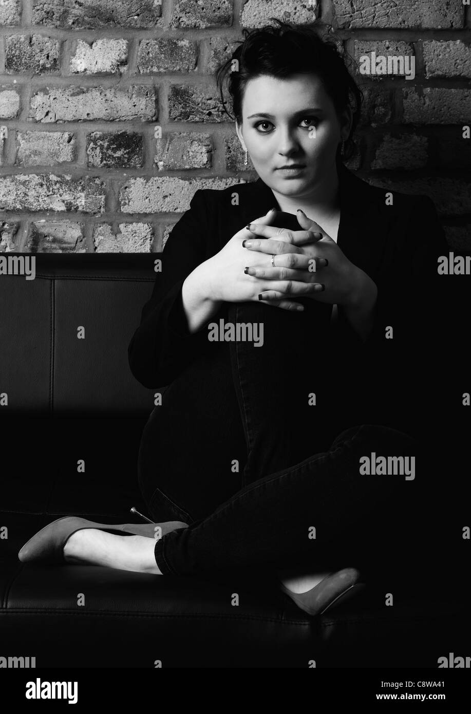 Black and white portrait of young woman sitting on a couch Stock Photo ...