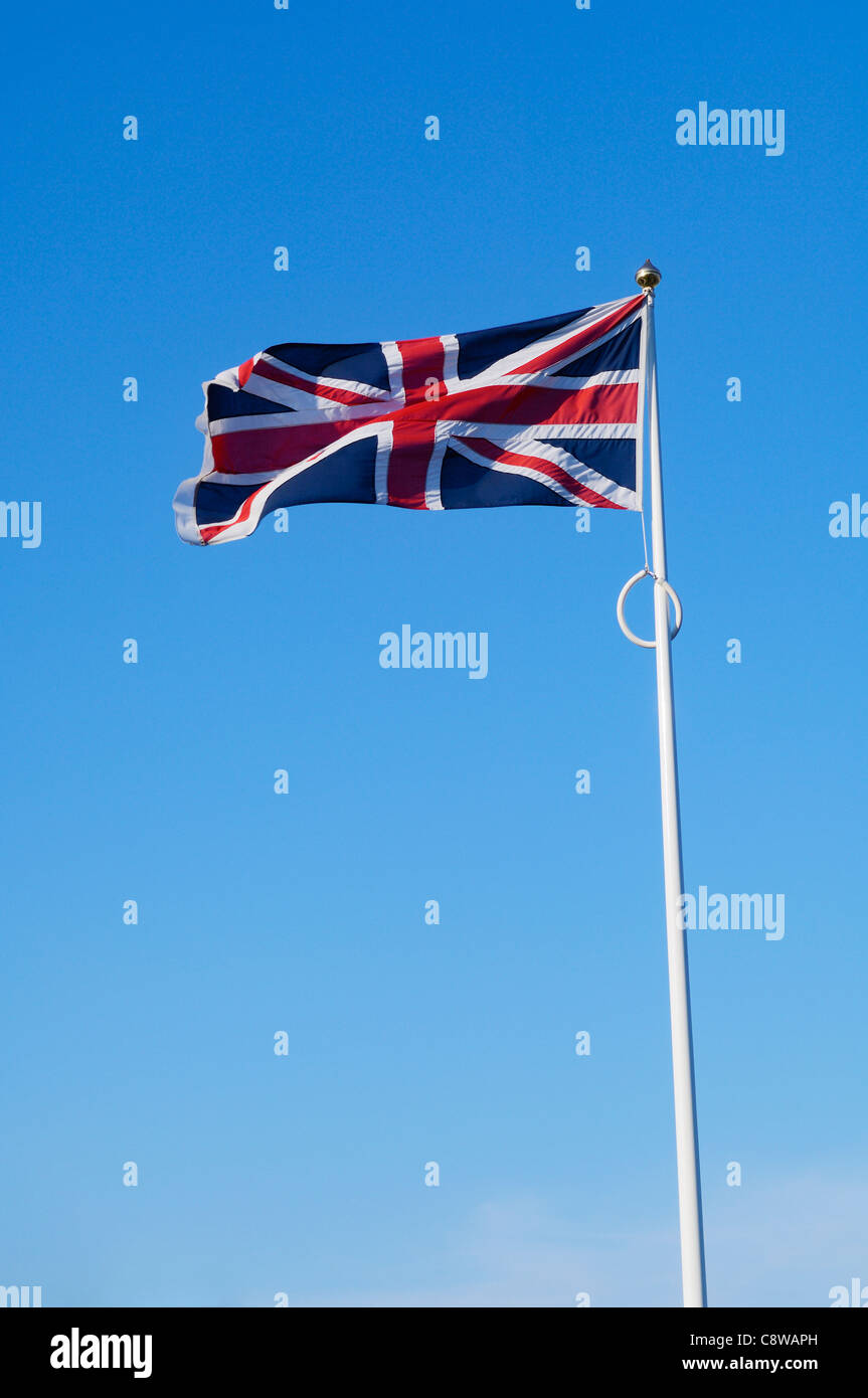 The flag of The United Kingdom flying against a clear blue sky. Stock Photo