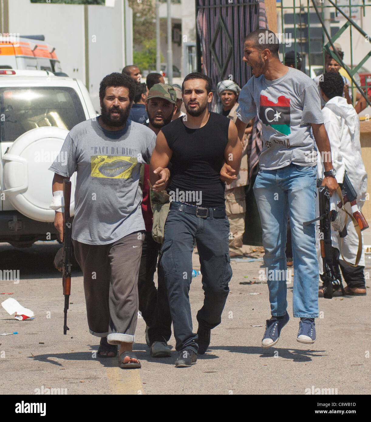 Rebels with a captured Gaddafi loyalist prisoner in the first day of the liberation of Tripoli Stock Photo