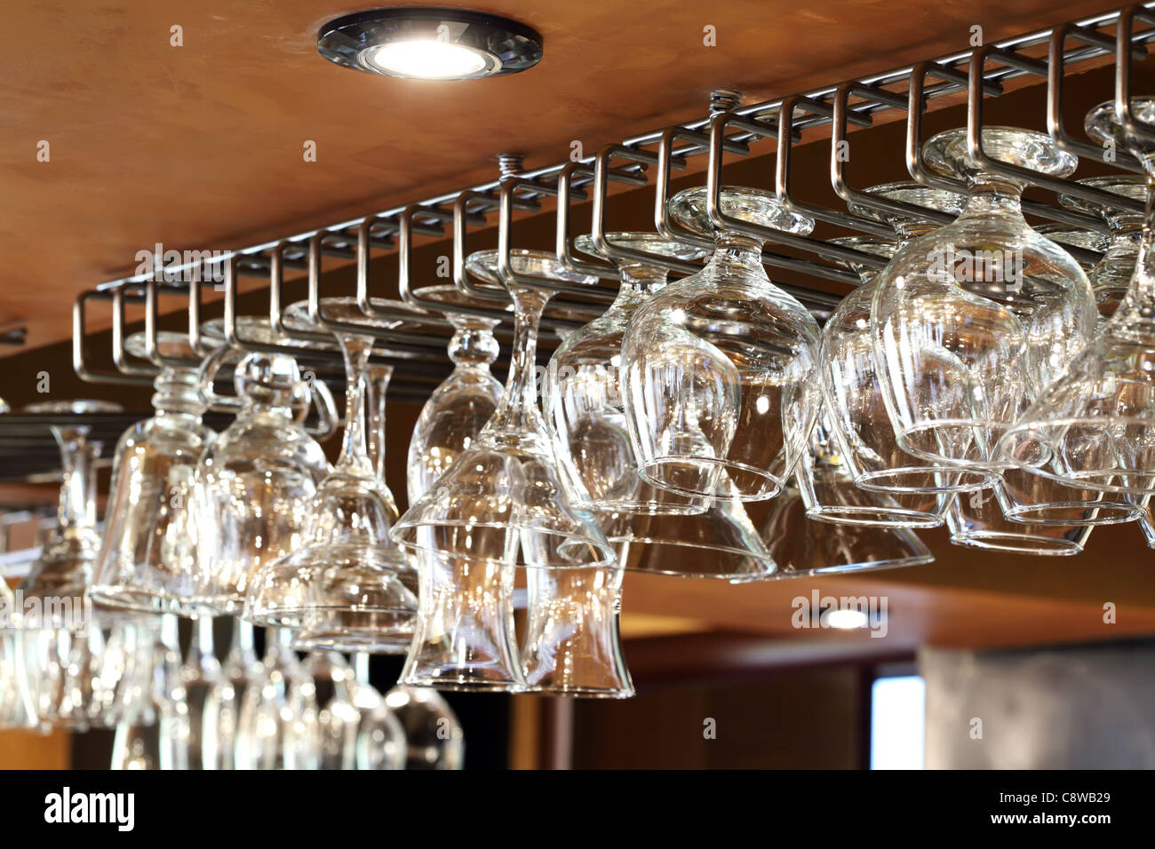 Wine and cocktail glasses hanging upside down in row Stock Photo Alamy