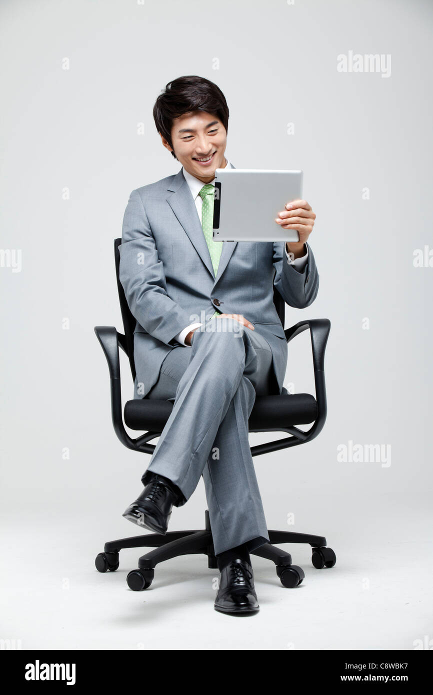 Asian Businessman Looking At Digital Tablet Stock Photo - Alamy