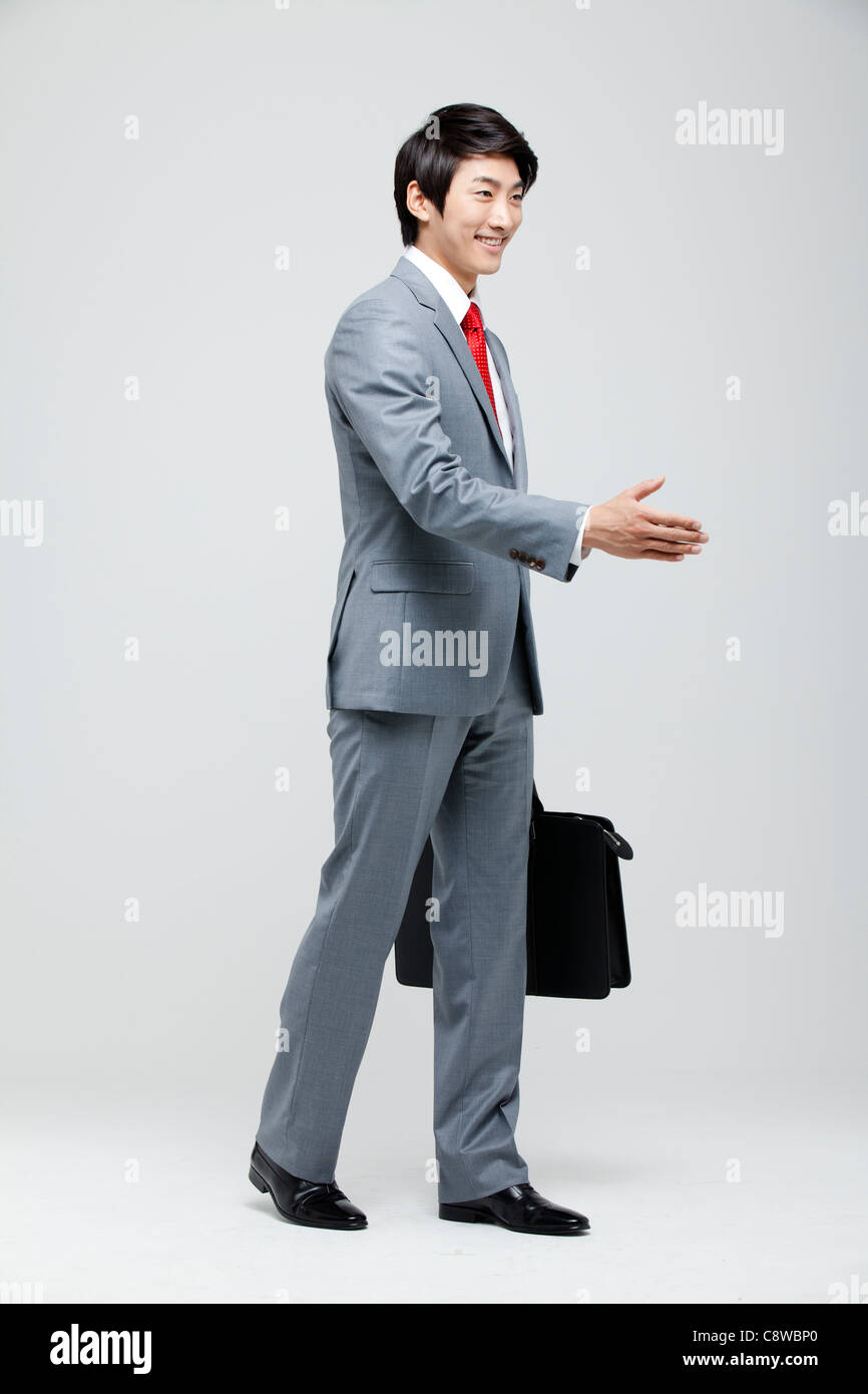Asian Businessman Extending A Hand To Shake Stock Photo