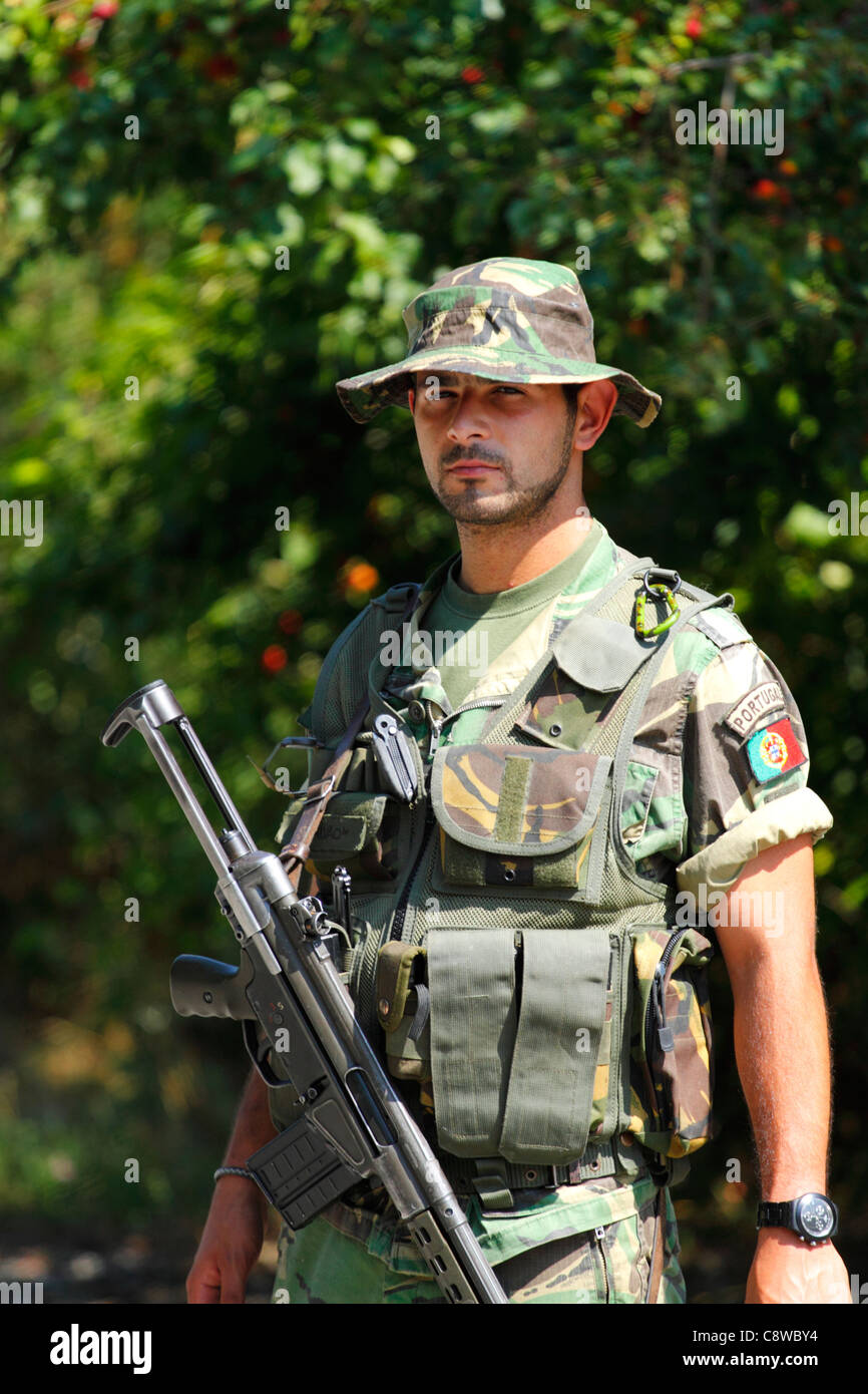Portuguese KFOR soldier with assault rifle on guard on a road block in Kosovo Stock Photo