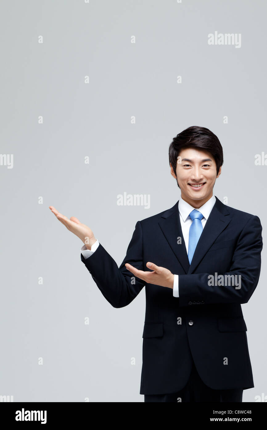 Portrait Of Smiling Asian Businessman Showing With Hand Stock Photo - Alamy