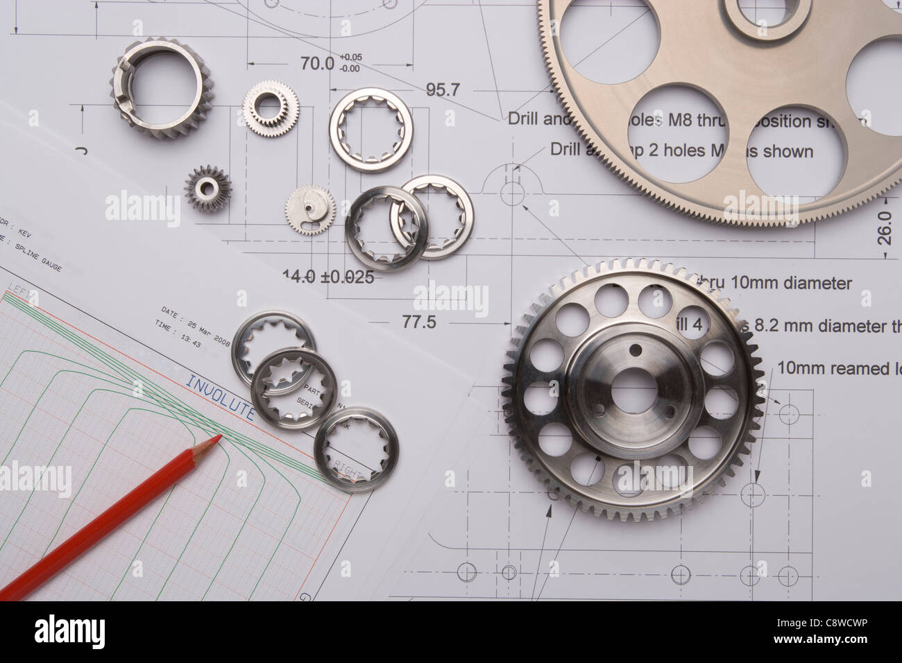 precision cut cogs and gears overlay technical drawings and quality control data and paperwork Stock Photo