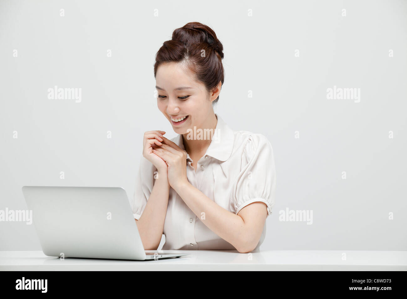 Asian Businesswoman Sitting At A Desk Using Laptop Stock Photo - Alamy