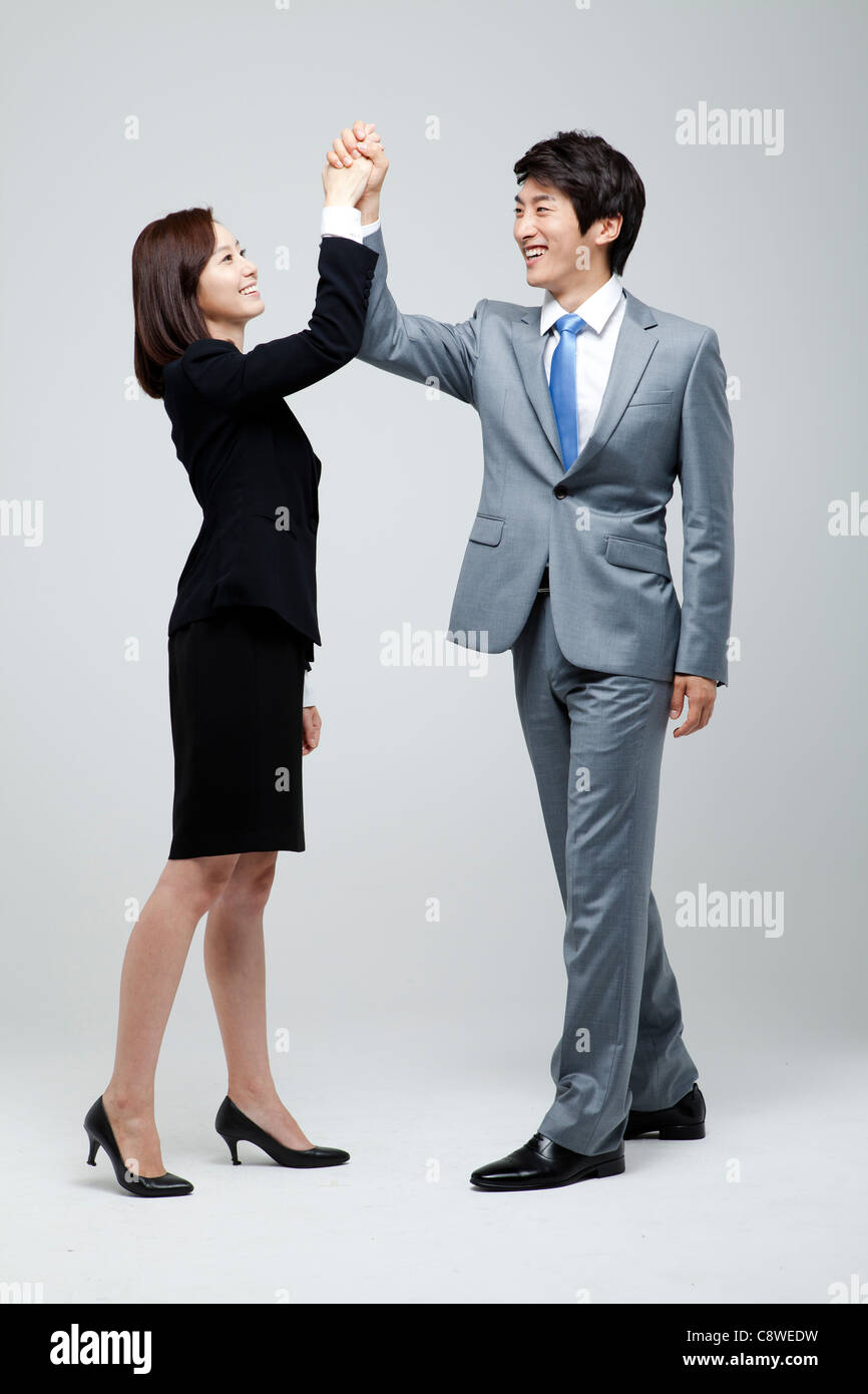Asian Businessman And Businesswoman Joining Hands Stock Photo