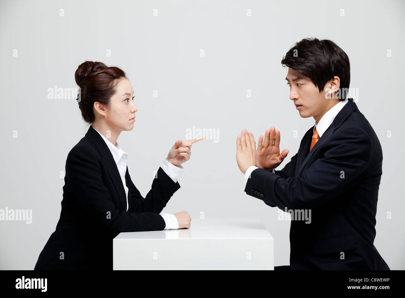 Asian Businesswoman And Businessman Sitting Face To Face Stock Photo