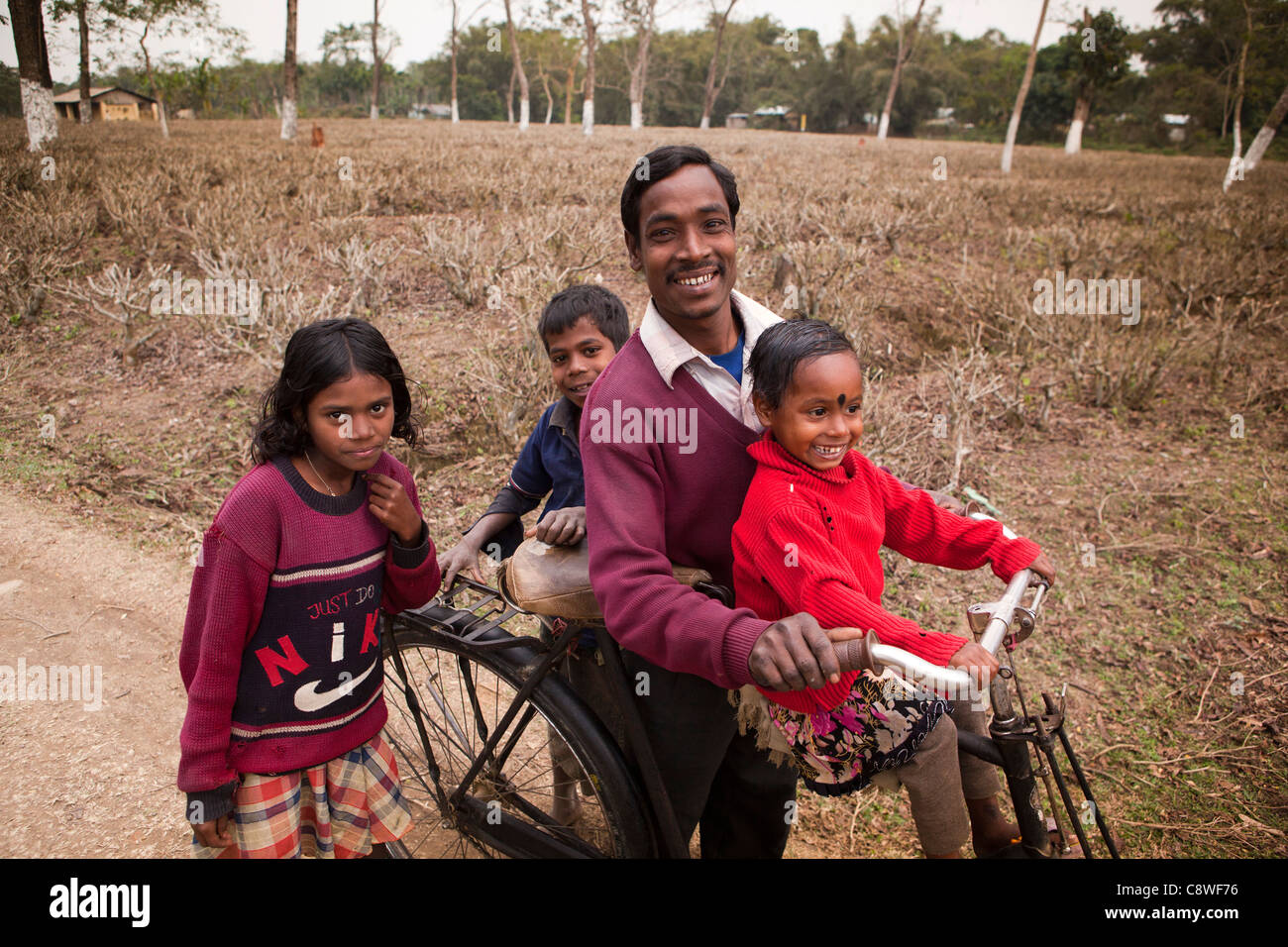 India, Assam, Jorhat, Gatoonga Tea Estate, worker with three of his young children Stock Photo