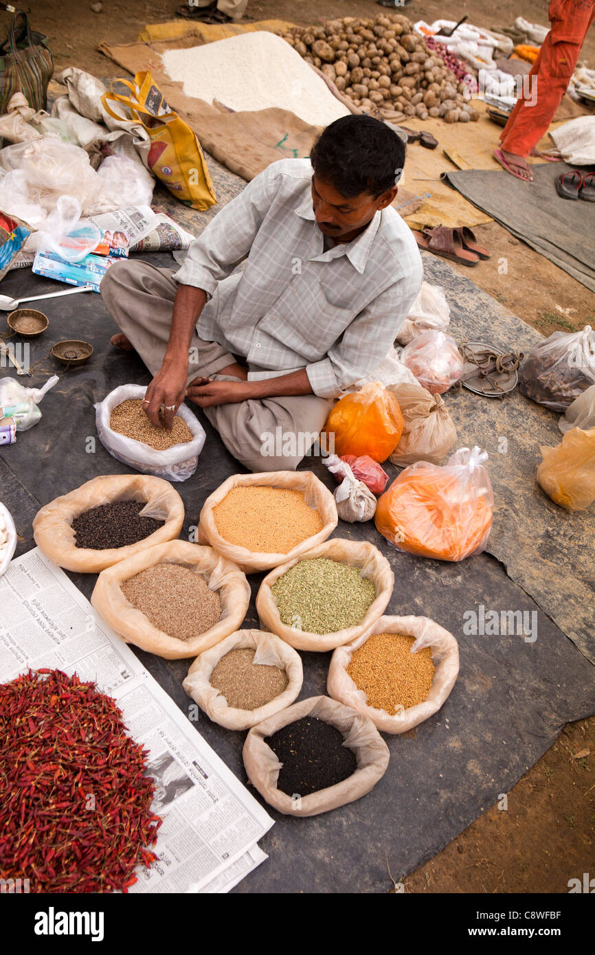 India, Assam, Jorhat, Gatoonga Tea Estate village market, trader selling spices Stock Photo