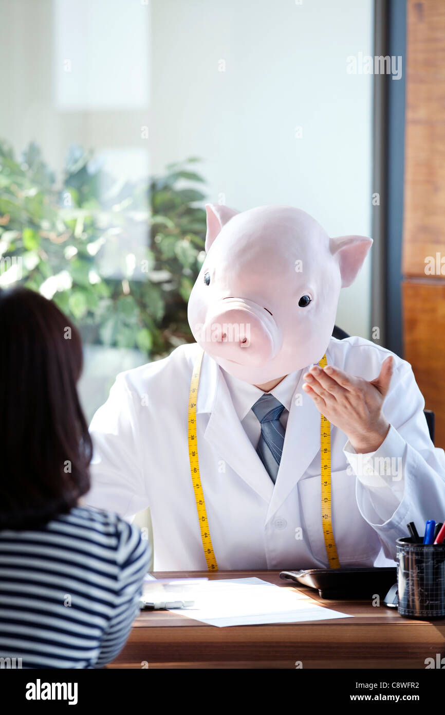 Pig Head Nutritionist With Patient At Desk Stock Photo