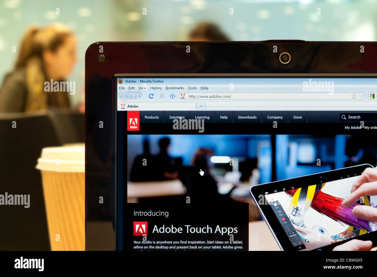 The Adobe website shot in a coffee shop environment (Editorial use only: print, TV, e-book and editorial website). Stock Photo