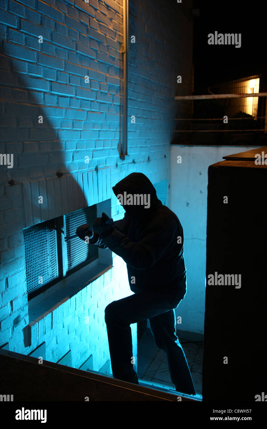 Burglar in a private house, basement. Nighttime burglary. Breaking into