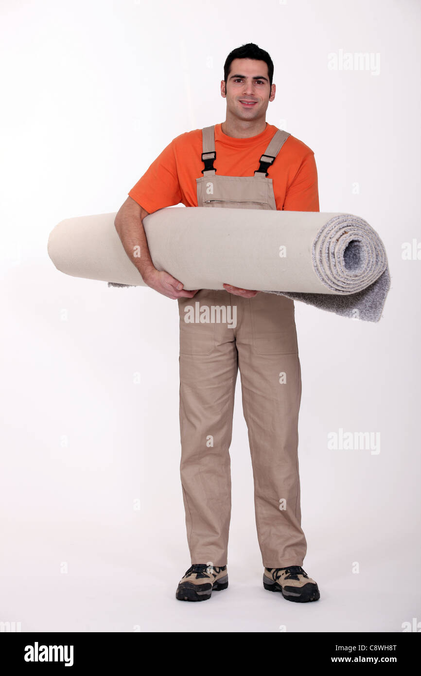 Carpet fitter carrying a roll of carpet Stock Photo Alamy
