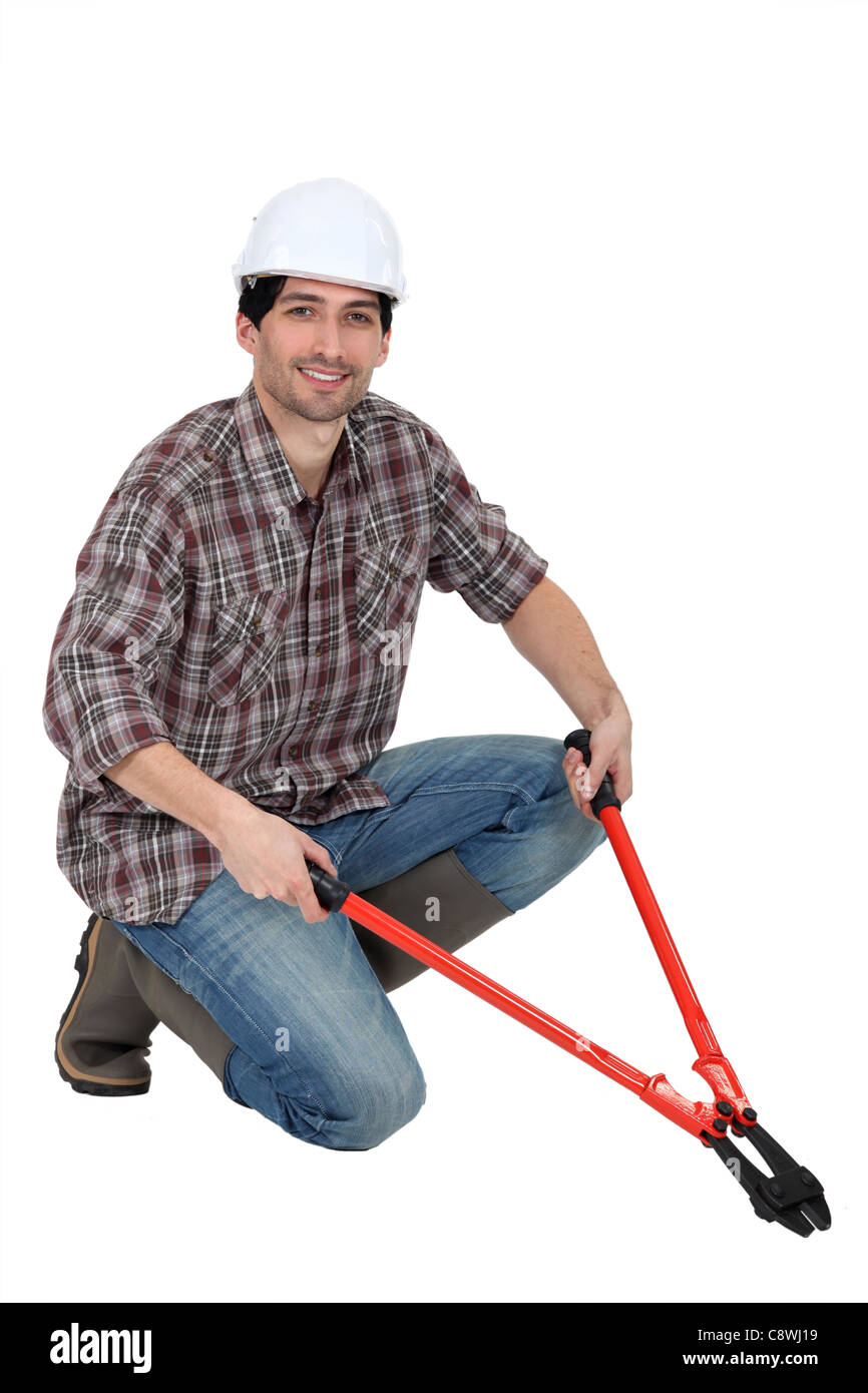Man kneeling with boltcutters Stock Photo Alamy