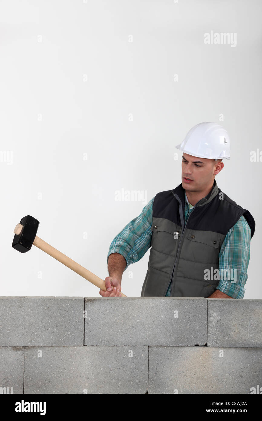 Man hitting wall with sledgehammer hi-res stock photography and