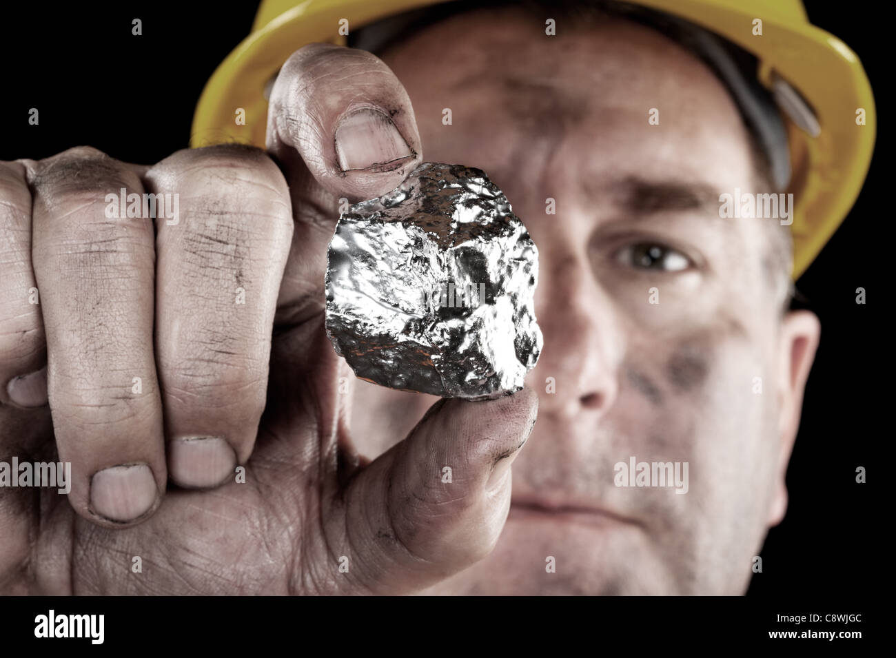 A silver miner shows off his newly excavated silver nugget. Stock Photo