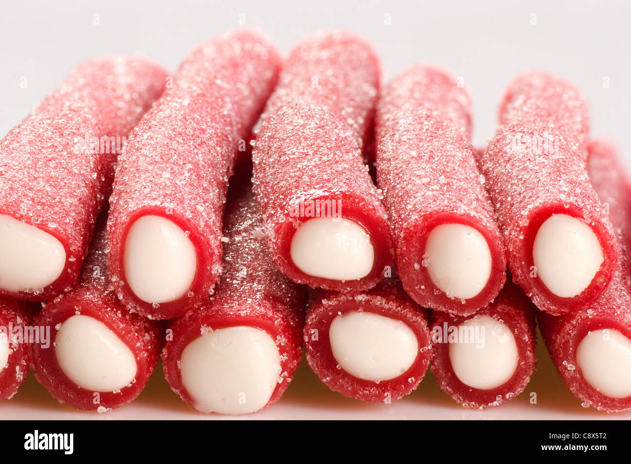 Red liquorice candy bars, filled and sugared Stock Photo Alamy