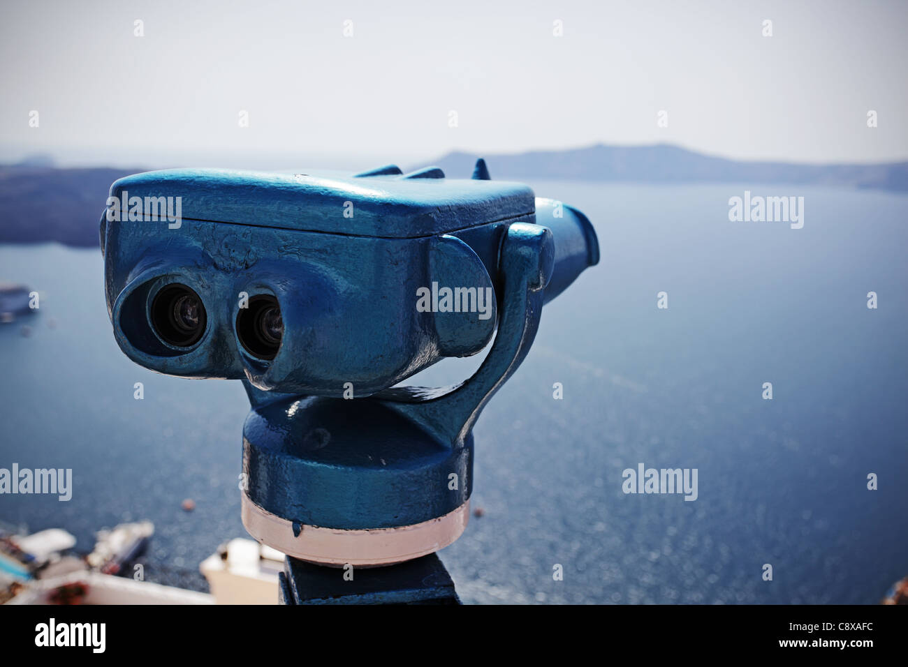 Coin operated binocular against harbor of Fira, Santorini island, Greece. Stock Photo