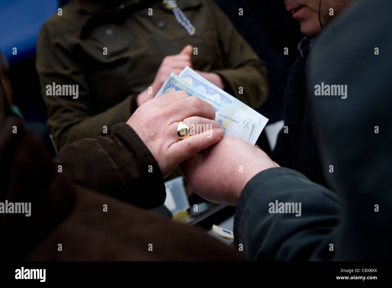 Money changing hands at Cheltenham horse racing. Stock Photo