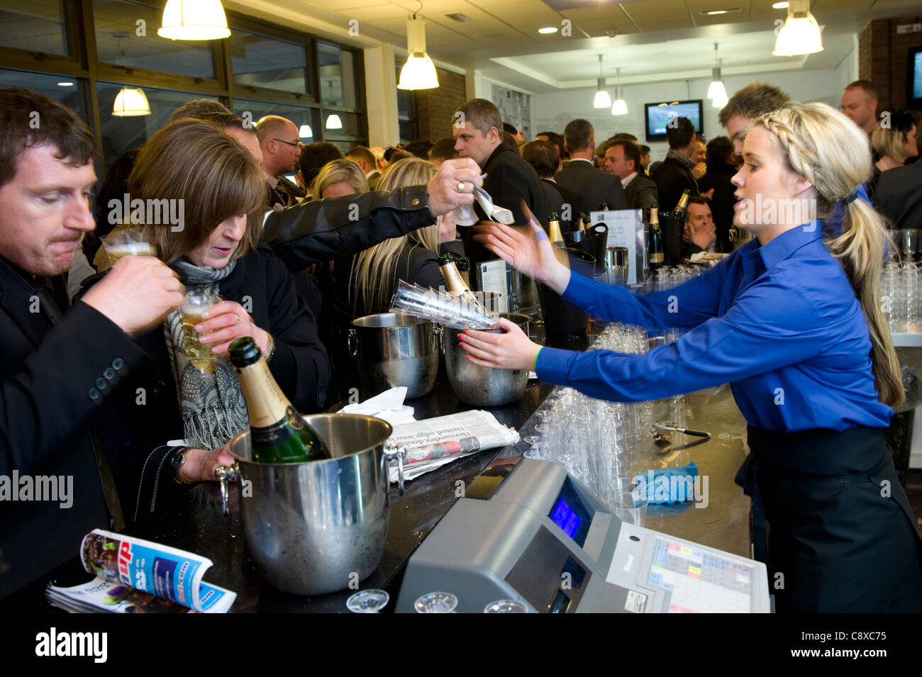 Punters buying champagne in the champagne Bar at Cheltenham Horses racing course. Stock Photo