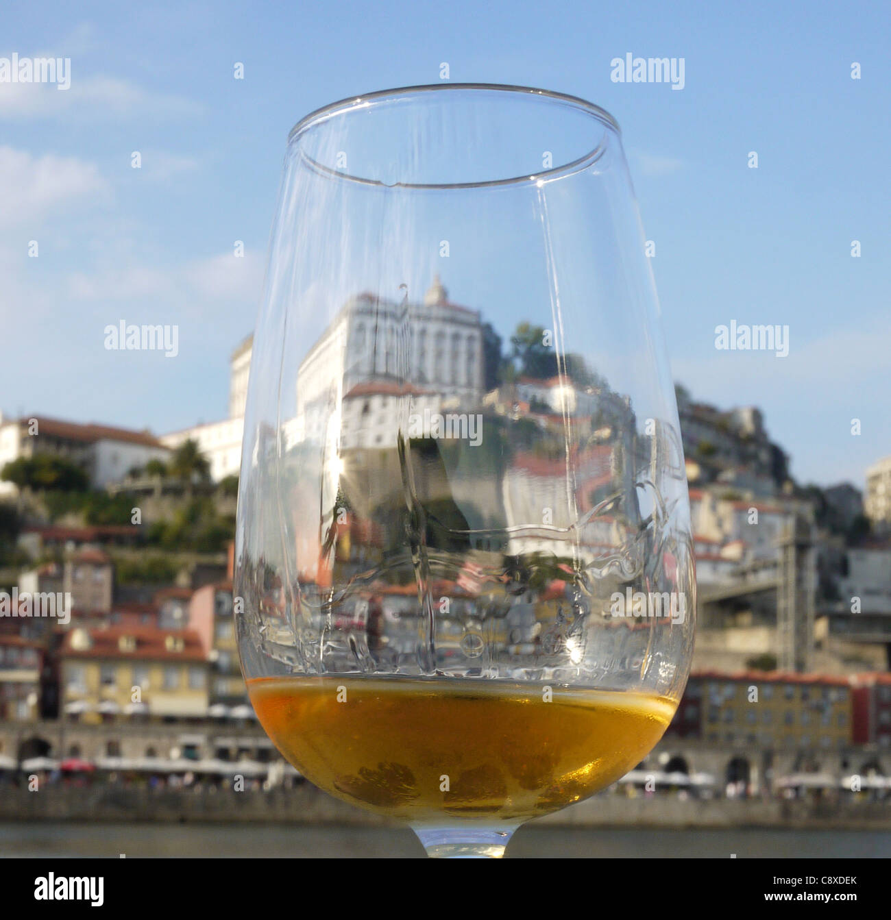 A glass of chilled white port in front of the waterfront in the city of