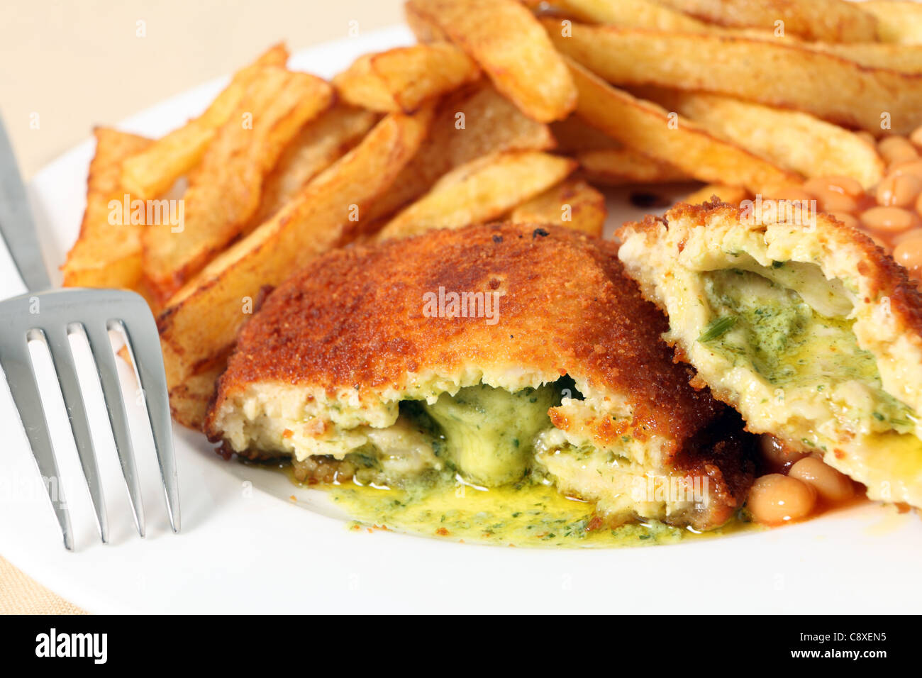 A chicken kiev showing the garlic butter and parsley filling, closeup
