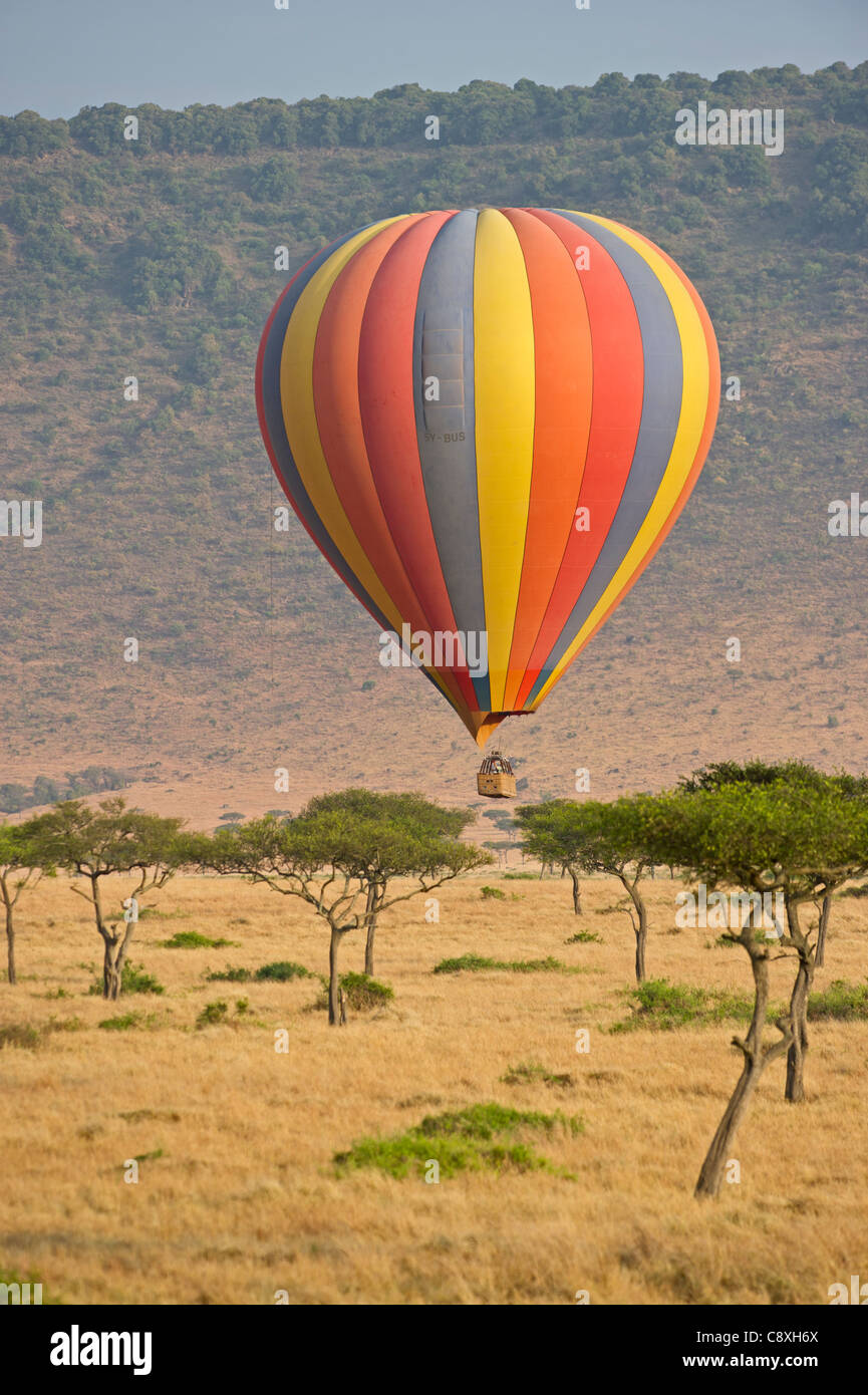 Hot air balloon carrying tourists over Masai Mara Kenya at dawn Stock Photo