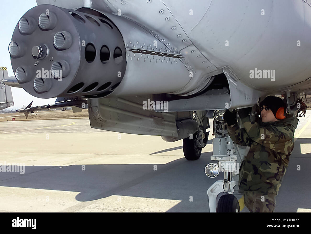 OSAN AIR BASE, Korea -- Senior Airman Andres L. Munoz inspects the gatling gun of an A-10 Thunderbolt II during an end of runway inspection here March 3. Senior Airman Munoz is a weapons specialist with the 51st Aircraft Maintenance Squadron. Stock Photo