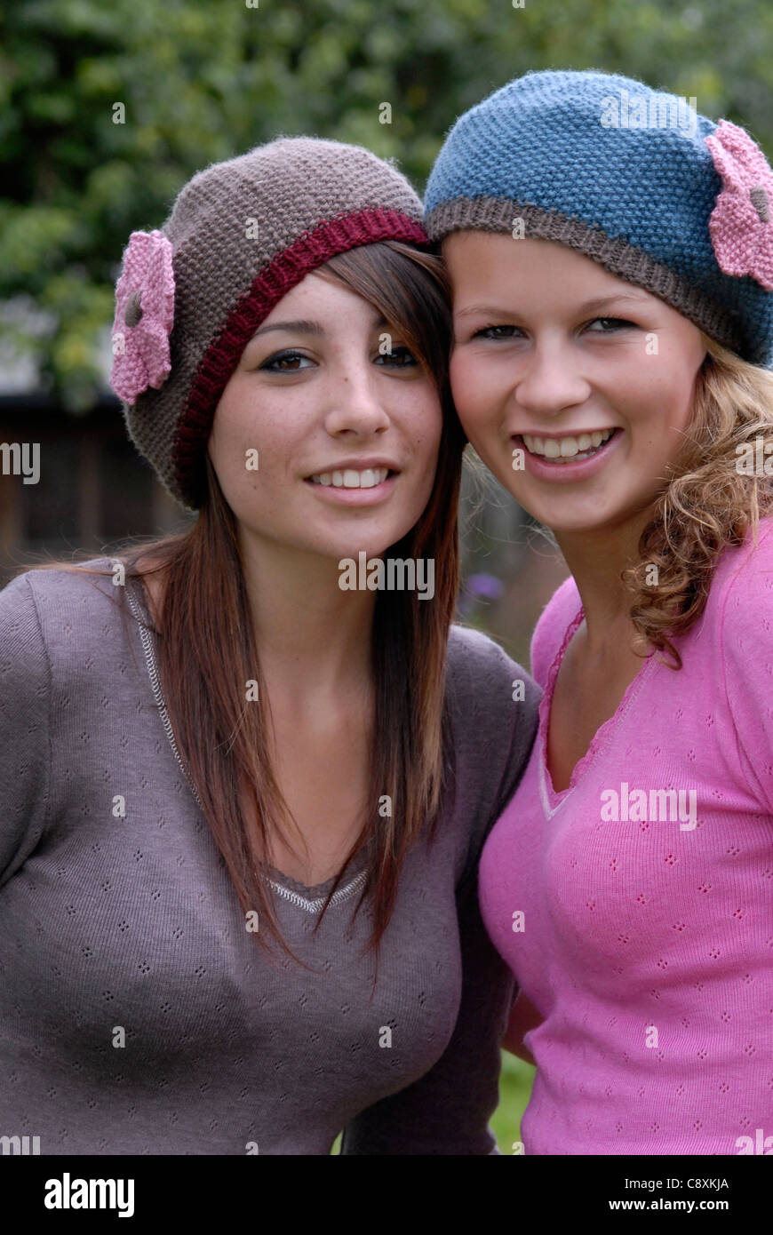 Two teenage girls wearing the same hats posing together Stock Photo - Alamy