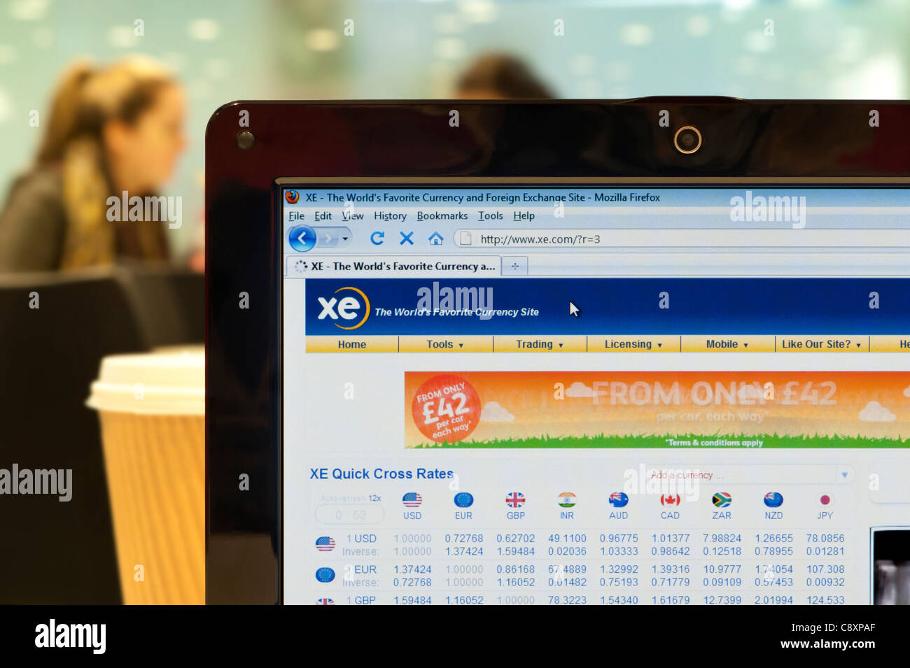 The XE.com website shot in a coffee shop environment (Editorial use only: print, TV, e-book and editorial website). Stock Photo