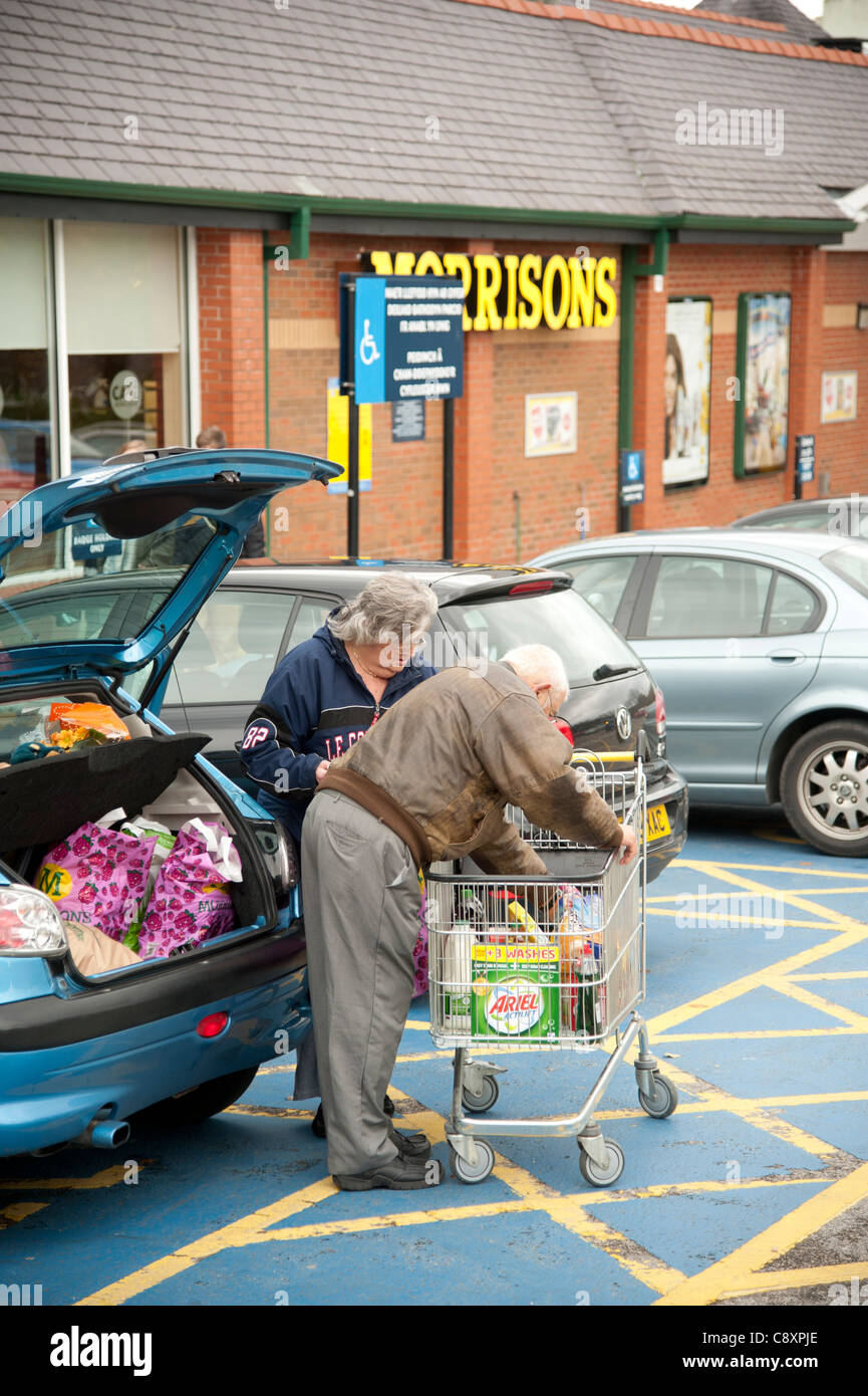 A couple loading their car with shopping at Morrisons store, Bangor Wales UK Stock Photo