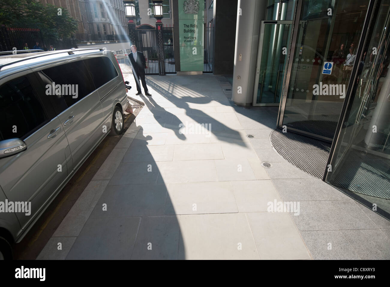 Man shadow - security bodyguard outside Rolls Building London Roman Abramovich security man waits for him to leave Stock Photo