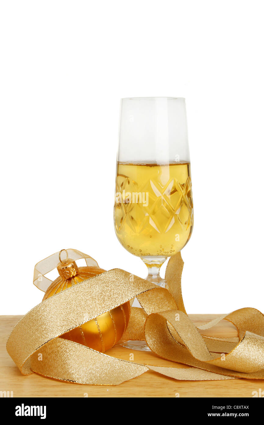 Glass of champagne with a gold ribbon and Christmas bauble decoration against a white background Stock Photo