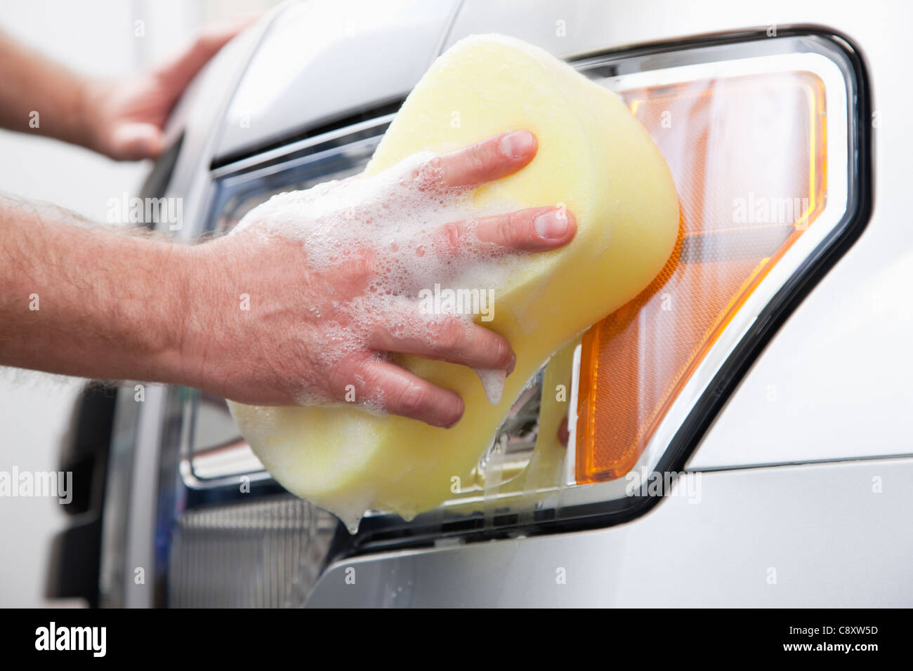 USA, Illinois, Metamora, Close-up of man's hand cleaning headlight Stock Photo