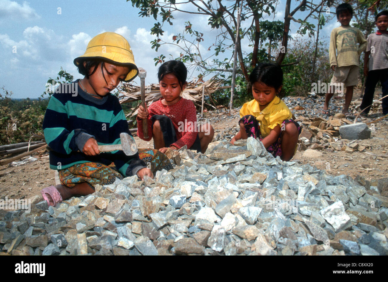 Child labourers work in a quarry breaking stones to build roads. Takeo ...