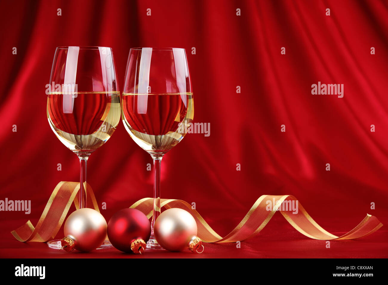 Glasses of champagne with golden ribbon and balls on festive background. Stock Photo
