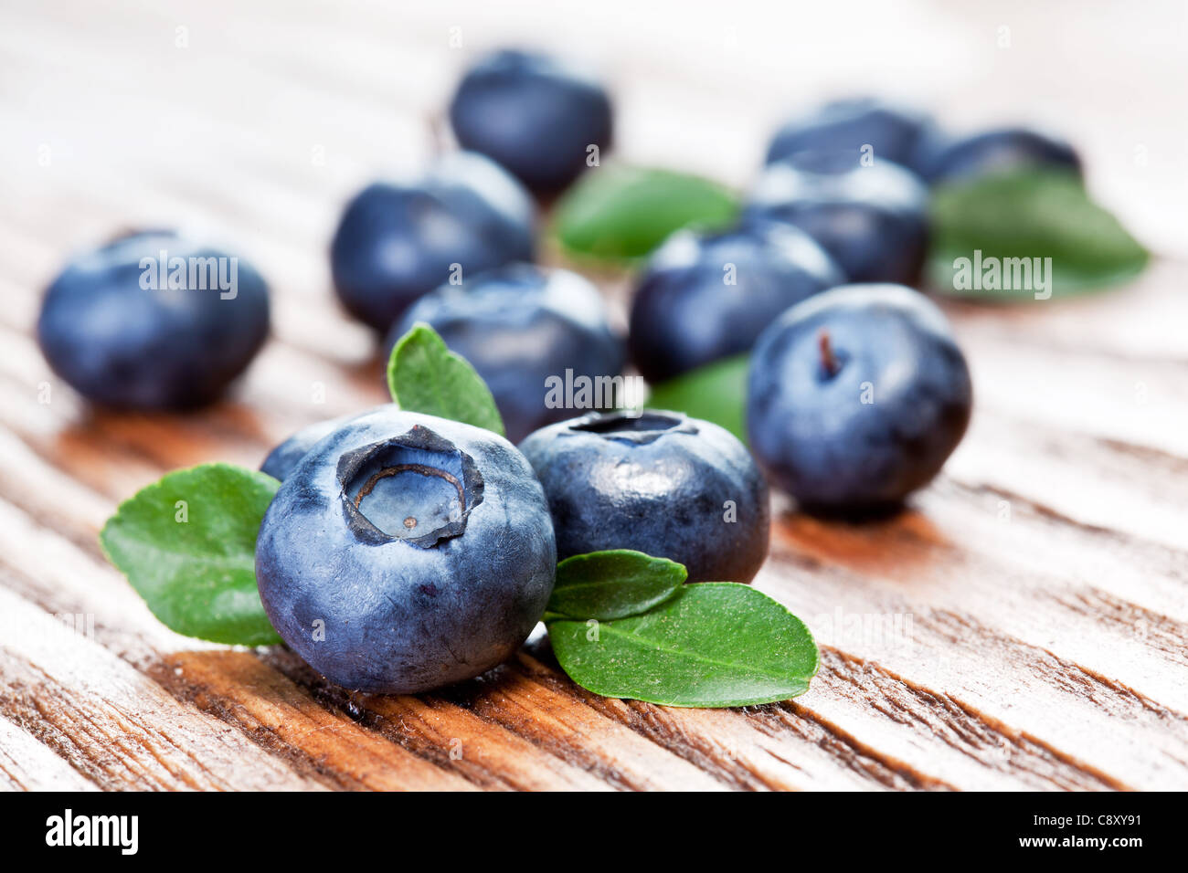 Blueberries with leaves on wooden background. Stock Photo