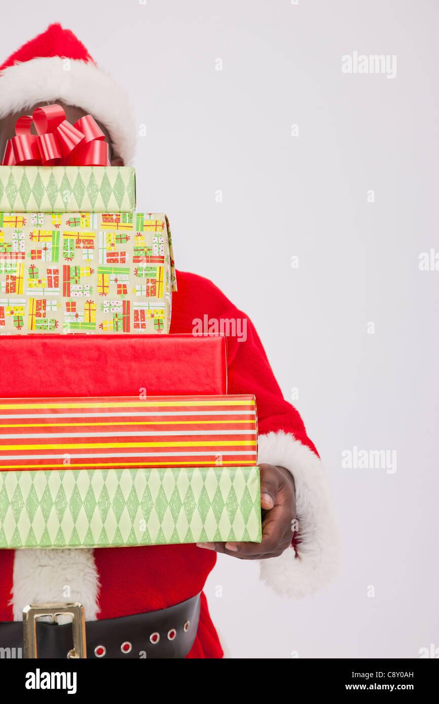 USA, Illinois, Metamora, Santa Claus holding stack of Christmas ...
