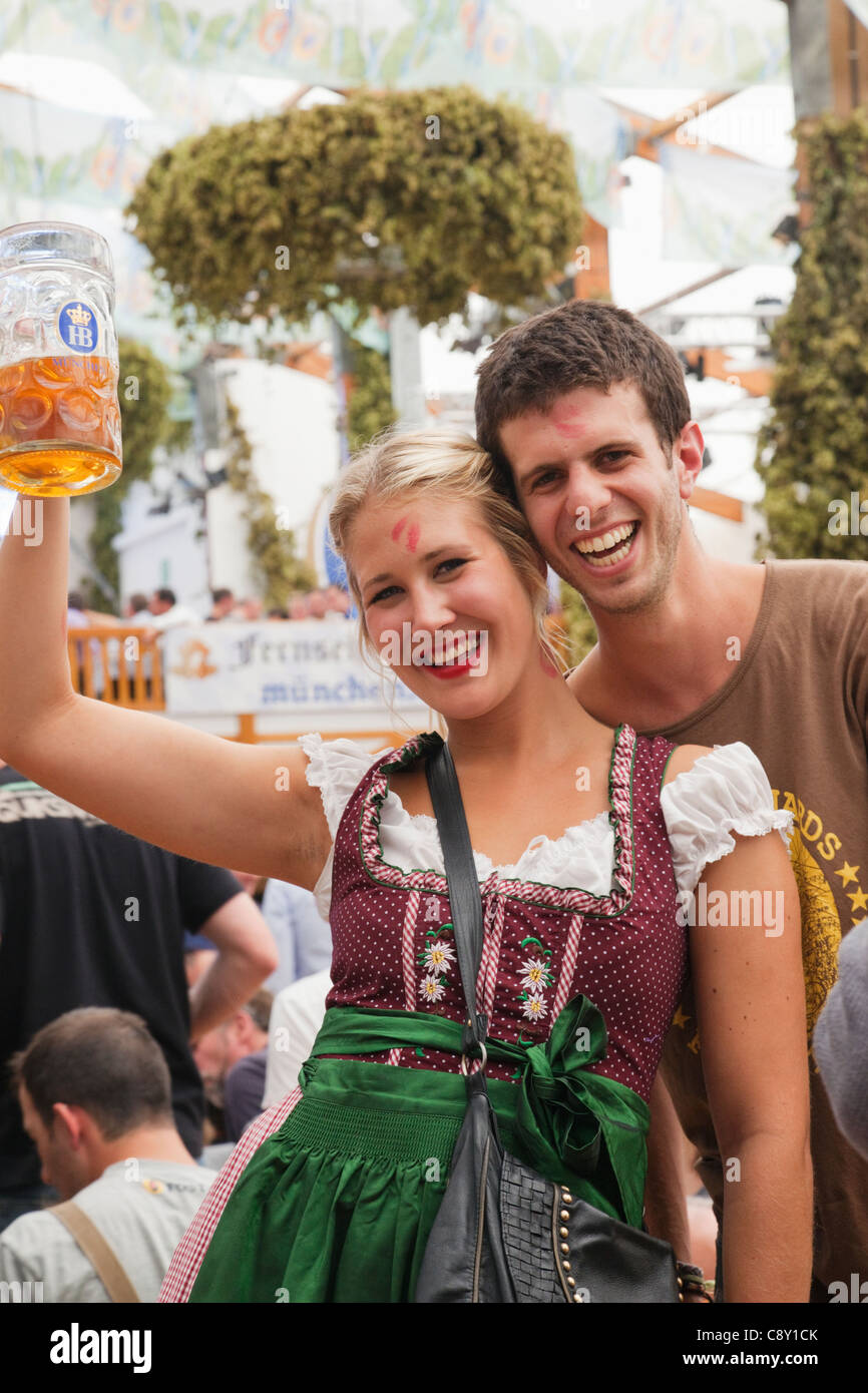 Germany, Bavaria, Munich, Oktoberfest, Couple in Bavarian Costume Drinking Beer Stock Photo