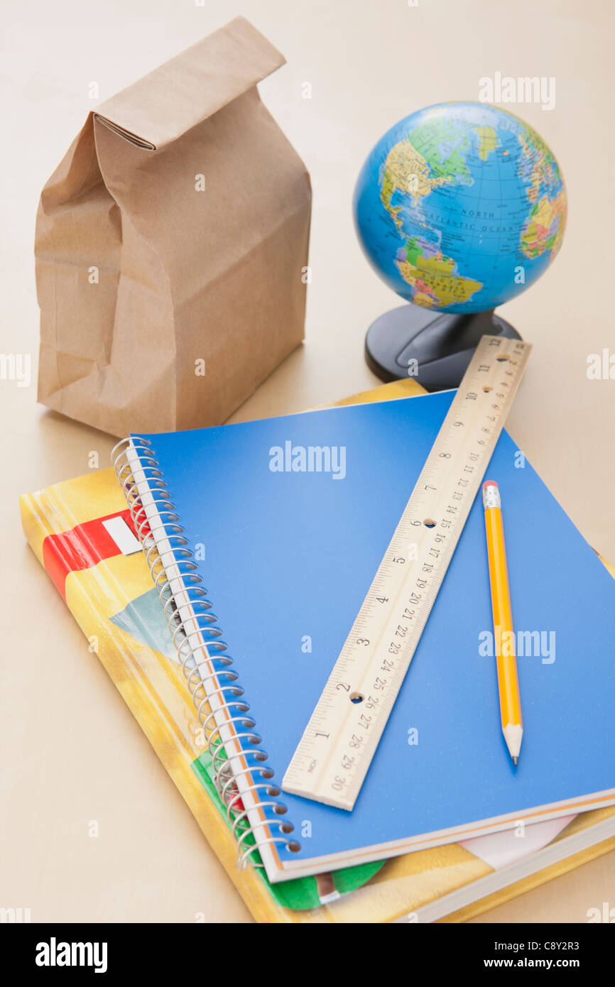Studio shot of notebook, lunch bag and globe Stock Photo