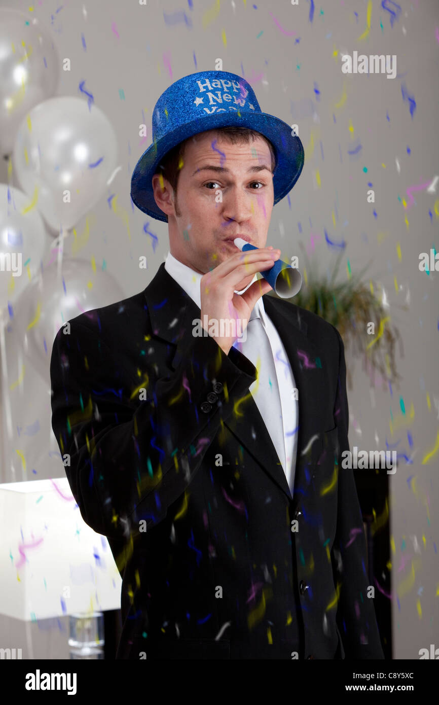 Young man celebrating birthday, blowing Stock Photo
