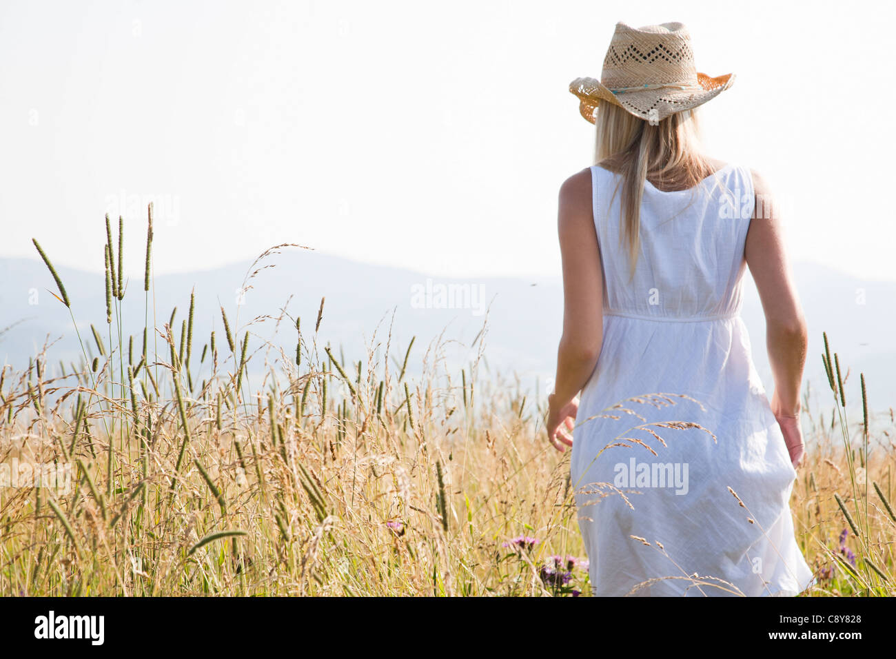 young blond woman standing in field Stock Photo - Alamy