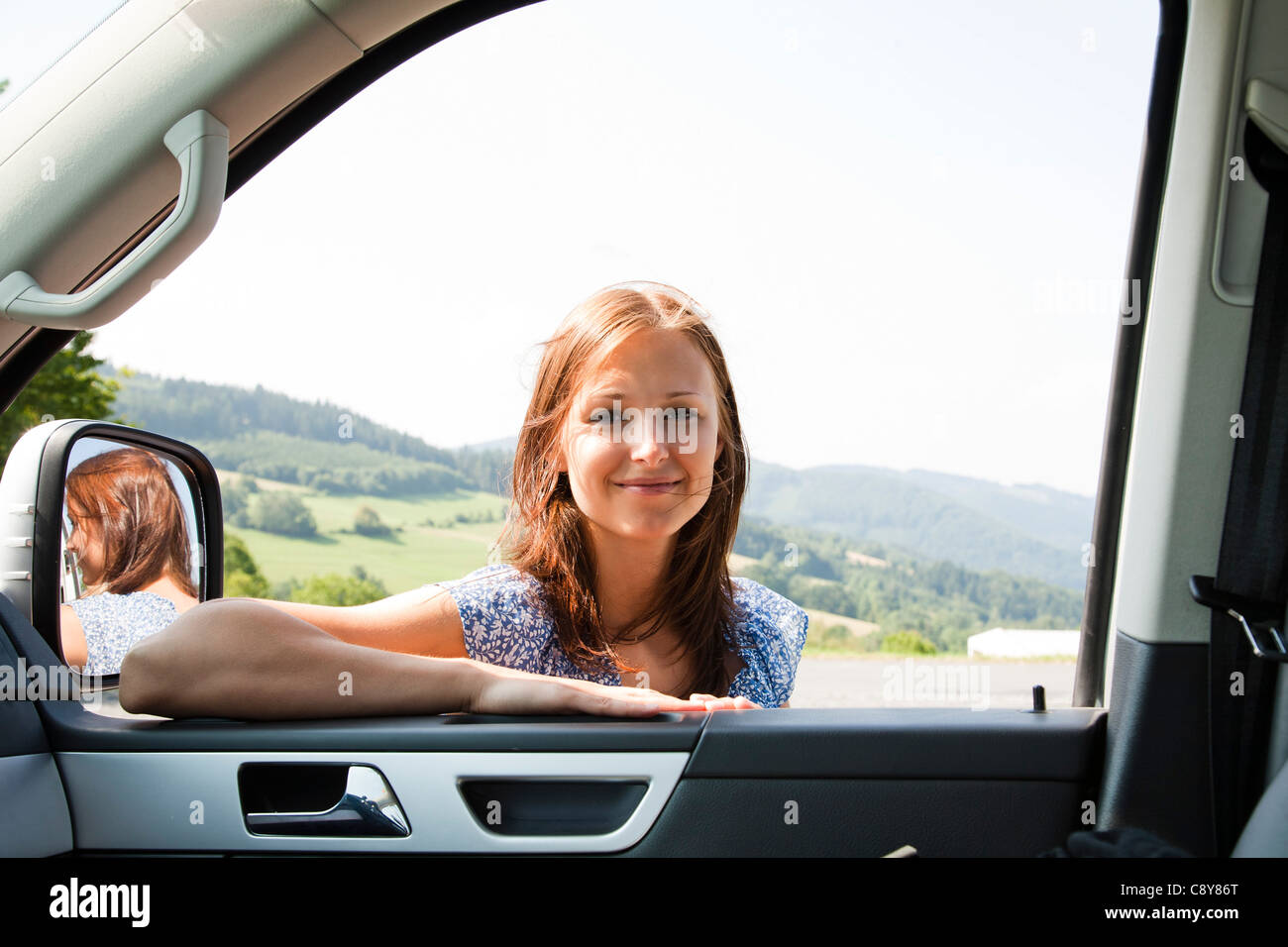 portrait of young woman looking through car window Stock Photo