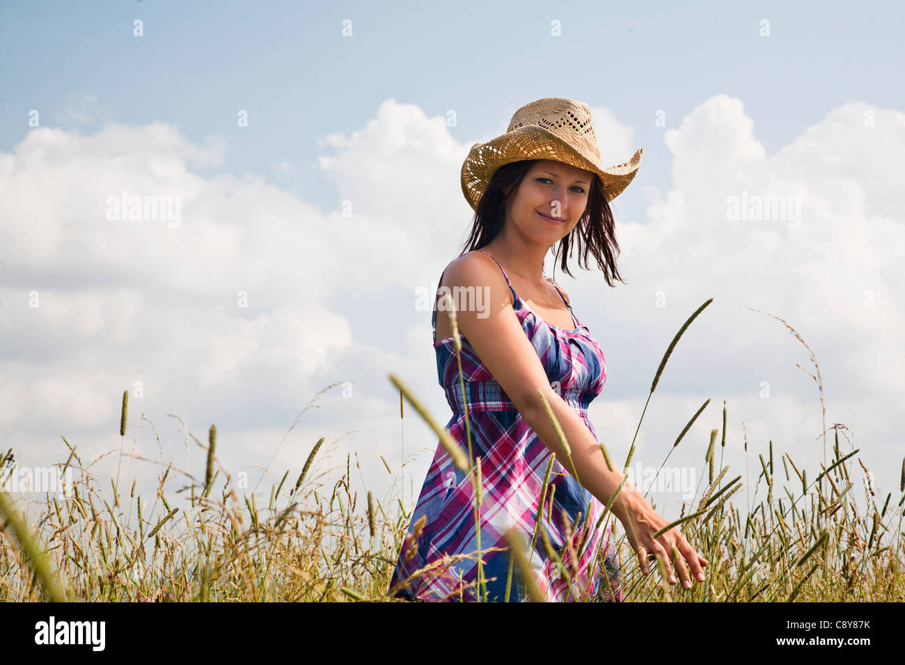 young woman standing in field Stock Photo - Alamy